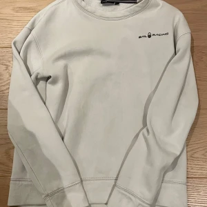 Vit Sail Racing tröja - Säljer en vit Sail Racing tröja. Använd bara några gånger och har inte använts på ett långt tag eftersom jag växt ur. Storlek: 176/xs, normal passform. Det finns inga synliga tecken på slitage eller skavanker.