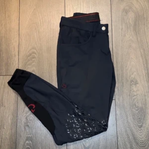 Cavalleria Toscana ridbyxor  - Halvskodda/knäskodda ridbyxor från Cavalleria Toscana. Marinblå, storlek IT 38 = svensk 34, normala i storleken. Fint skick, professionell lagning av skräddare i sömmen (se sista bilden).  Älskar dessa men de är tyvärr för små för mig.  Nypris 2800kr. 