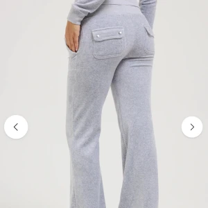 Grå Juicy Couture byxor - Snygga och bekväma grå mjukisbyxor med praktiska fickor. Byxorna har en avslappnad passform och snörning i midjan för extra komfort. Köpta för 1200kr.