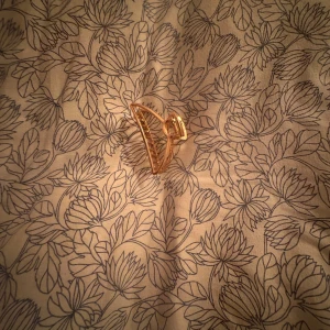 Guldfärgad hårklämma - Elegant guldfärgad hårklämma med ett unikt blommönster. Perfekt för att ge en stilfull touch till din outfit. Passar bra till både vardag och speciella tillfällen.