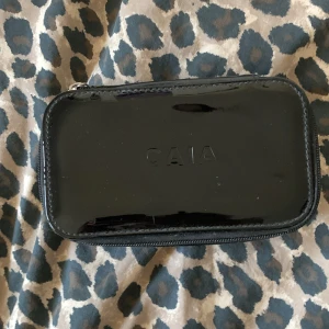 Svart necessär fårn CAIA - Snygg neccär från caia då jag har använt den 1 gång.Jätte fint skick och det får plants men mascara och sånt ord:235 tror jag men säljer den för att jag har slutat använda den.❤️