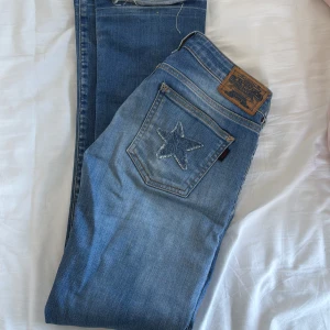 Lågmidjade Blå jeans från Crocker - Coola lågmidjade jeans ifrån crocker med stjärnor på bakfickorna.⭐️