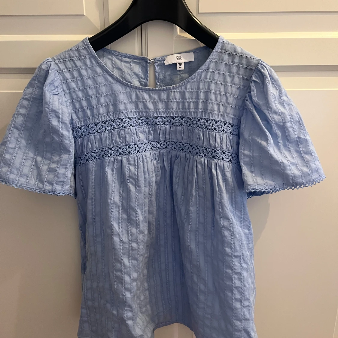 Ljusblå blus med spetsdetaljer