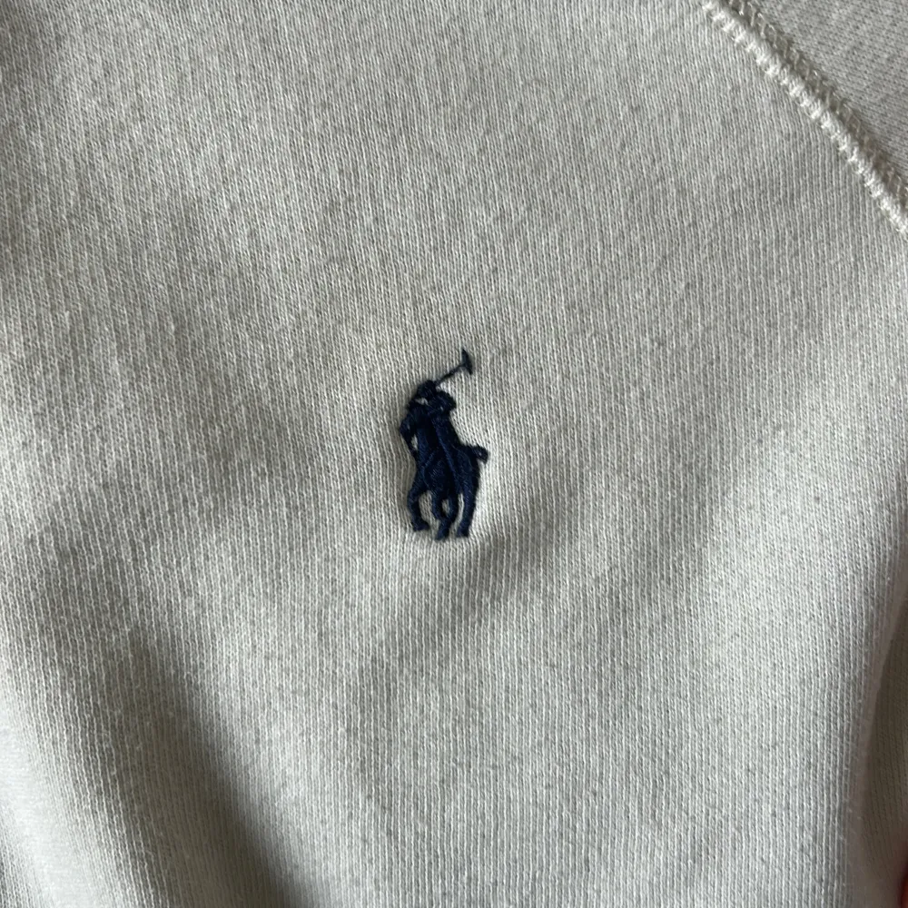 Säljer en stilren vit hoodie från Ralph Lauren med det klassiska broderade marinblå logotypen på bröstet. Hoodien har en stor ficka framtill och en bekväm huva. Perfekt för en avslappnad look. snören saknas🫶🏼. Neuletakit & Villapaidat.