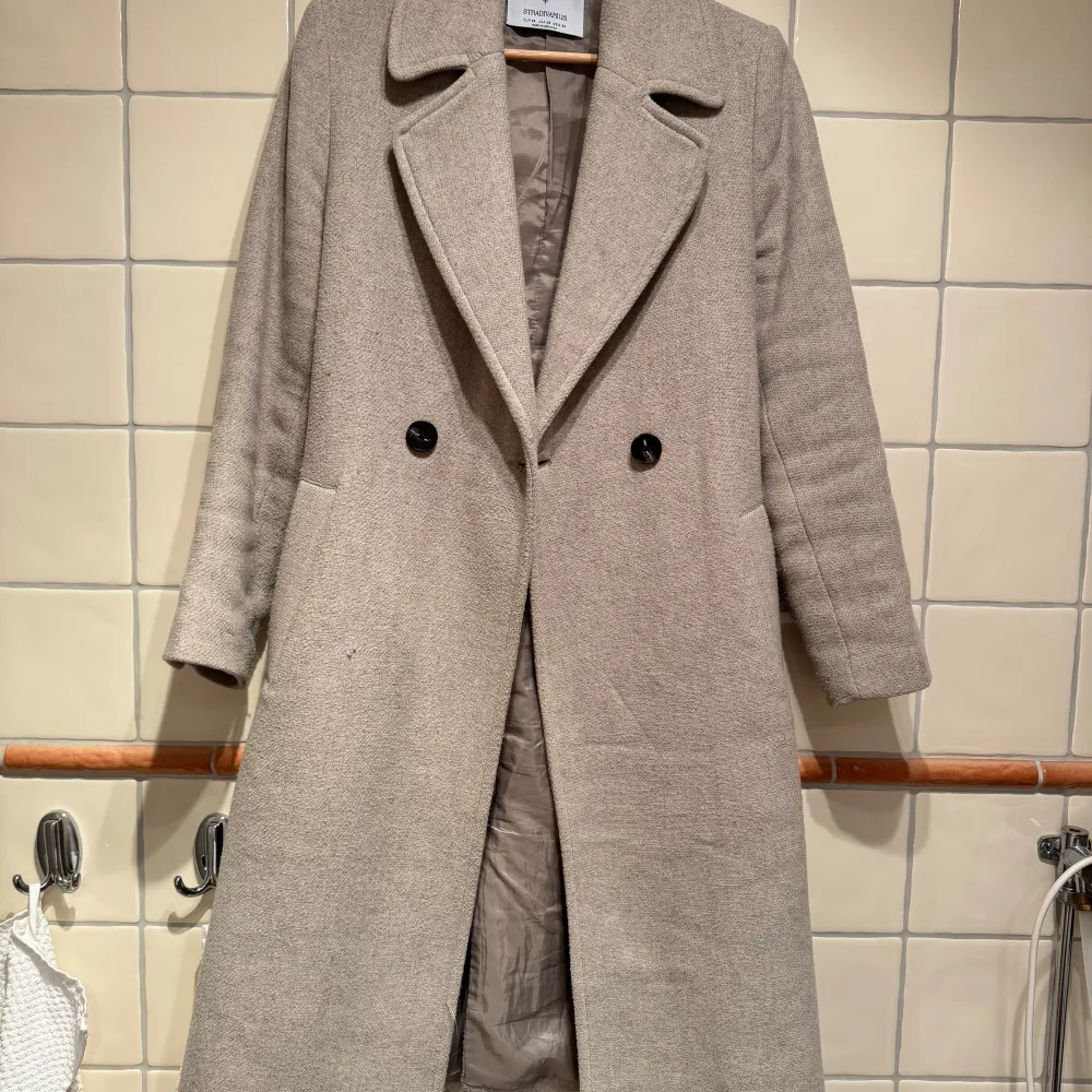 Stilren vårkappa från Stradvarius, köpt på Zalando. På sista bilden syns det vävda tygets mönster, samt en liten reva som går att lösa jättelätt om man är händig med nål och tråd. Kappan är i gott skick i övrigt men eftesom jag bara vill göra plats i garderoben så säljer jag den med 70% rabatt på vad den kostade mig på Zalando (999kr). Man kan fortfarande köpa en helt ny där. 🎀 Använd under en säsong.. Takit.