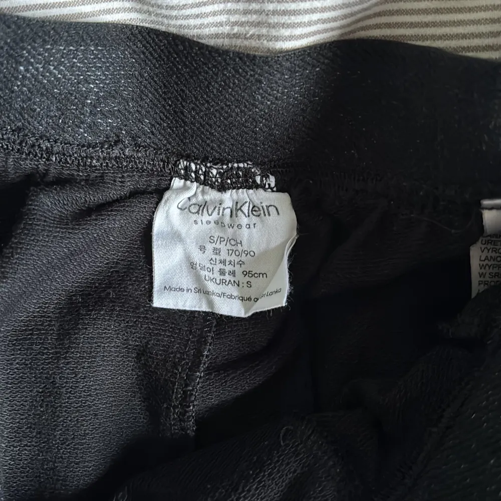 Säljer ett par svarta mjukisbyxor från Calvin Klein. De har en elastisk midja med märkets logga och ribbade muddar vid bensluten. Perfekta för en avslappnad stil.. Farkut & Housut.