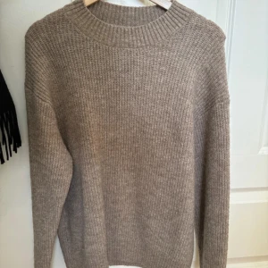 Beige stickad tröja från H&M - Tröjan är ribbstickad och har använts få gånger, den är i mörk beige/ljusbrun färg. Storlek M och satt oversized på mig som har XS/S. Tröjan är annars i väldigt bra skick och håller sin form. Den har inte blivit nopprig. Normal i storleken. 
