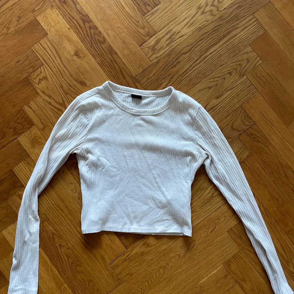 Säljer en vit ribbad topp med långa ärmar och croppad passform. Perfekt för lager-på-lager eller att bära som den är. Enkel och mångsidig design som passar till det mesta. . Yläosat.