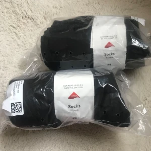 Strumpor 10-pack Hm x 2 - Säljer ett 10-pack svarta strumpor från H&M, tillverkade med Lycra. Perfekta för dagligt bruk och passar storlek EUR 43/45. Helt nya strumpor. Ett öppet pack och ett helt förslutet. 