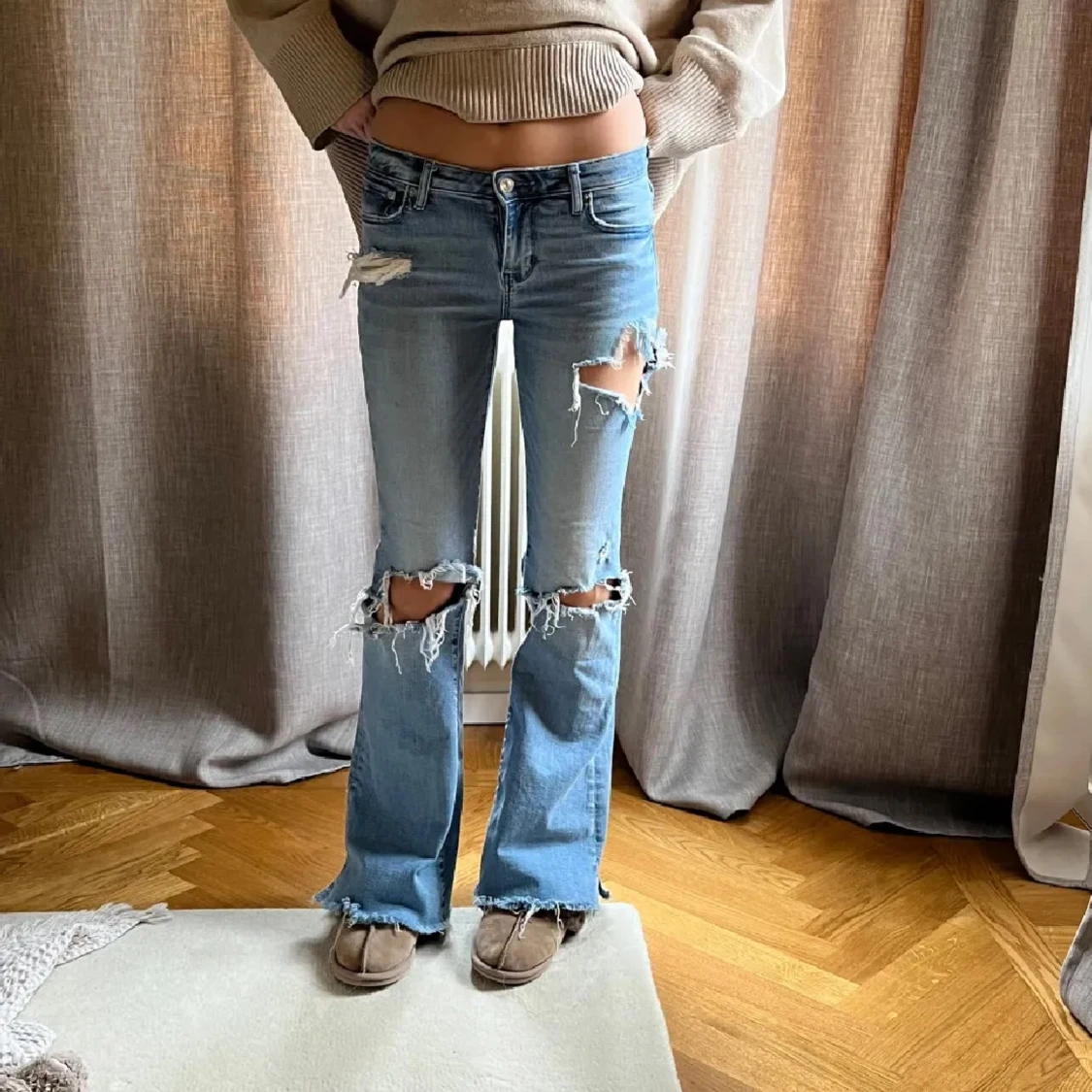 Blå slitna bootcut jeans