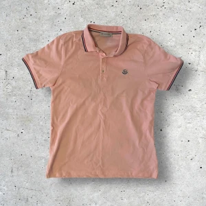 Moncler piké - Säljer denna rosa Moncler pikén i stl XL men passar mer som L skulle jag säga. Tröjan har inga defekter och är i väldigt bra skick! Skriv ifall ni har frågor, pris kan gå ner vid snabb affär.
