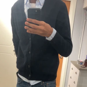 Cardigan - Säljer nu min snygga mörkblåa/ svarta kofta/cardigan i storlek S. Passar  till både skjorta och t-shirt. Enkel och stilren design som funkar till många tillfällen.