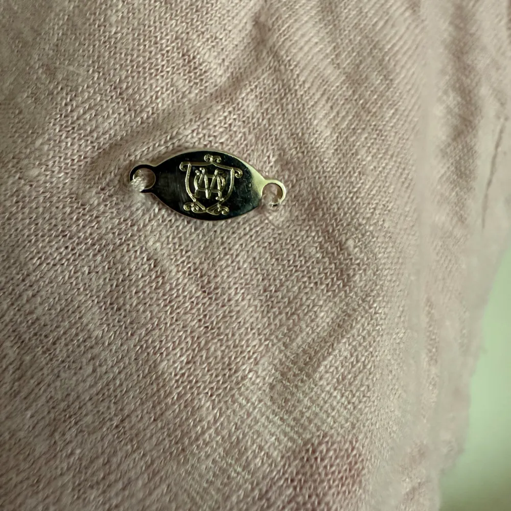 Säljer en söt rosa tröja från Massimo Dutti med v-ringning och knytning i ryggen. Tröjan har långa ärmar och en liten metalllogga framtill. Perfekt för en stilren look!. Neuletakit & Villapaidat.