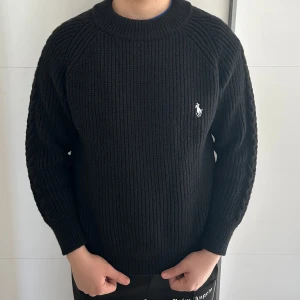 Svart stickad tröja från Ralph Lauren - Säljer en stilren svart stickad tröja från Ralph Lauren, den är perfekt för lite kyligare dagar. Har haft på mig den endast 1 gång utomhus, gillar inte hur den sitter på mig så säljer den, storlek XL köpte den för 1173kr och person på bilden är 185cm