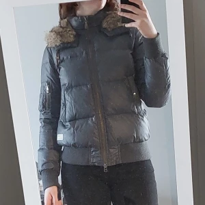 Grå jacka med pälskrage Odd Molly - En grå jacka/puffer jacket från Odd Molly med en mysig pälskrage och huva. Perfekt för kyliga dagar när du vill hålla dig varm och stilren. Vet ej storlek men passar mig som ofta har M, 172cm lång Extraknappar medföljes ej o tvättrådslappar bortklippta