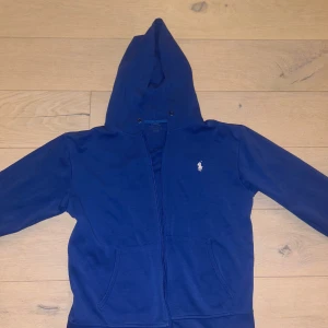 Ralph Lauren Zip Up Hoodie ( M ) Blå - En fel fri, oanvänd Ralph Lauren zip up hoodie i blå färg. Storlek: medium.