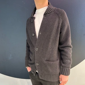 Grå kofta med knappar - Snygg grå kofta med stora knappar och ribbade muddar. Perfekt för kyligare dagar och lätt att matcha med olika outfits. Koftan har en klassisk design med en bekväm passform.