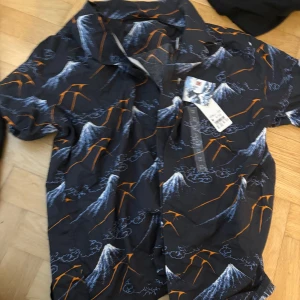 Svart kortärmad skjorta med bergsmotiv - Från uniqlo, bra skick