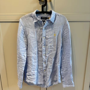 Ralph lauren Linne skjorta slim fit, ljusblå - Ralph lauren linne skjorta i mycket bra skick, skrynklig då den legat vikt. Cond 10/10 nypris ca 2300, storlek medium,. Skanna qr kod för verifiering. Pris diskuterbart vid snabb och smidig affär
