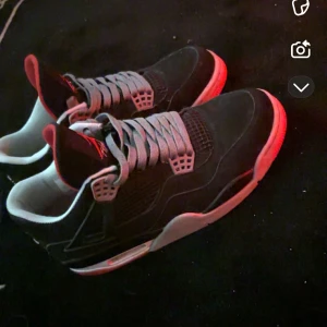 Jordan 4 Breds 2012 - Snygga Jordan 4 Retro Black Cement sneakers med en klassisk svart och grå färgkombination. Skorna har en ikonisk design med snörning och röda detaljer på sulan. Perfekta för sneakerheads som älskar stil och komfort. Skorna är använda. Skorna kommer med gråa, svarta och röda laces. Ingen skolåda tyvärr eftersom den blev förstörd av mitt syskon