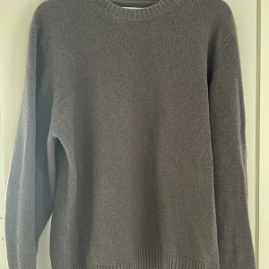 Grå stickad tröja från Samsøe Samsøe - Säljer en stilren grå stickad tröja från Samsøe Samsøe. Tröjan har en klassisk rund halsringning och långa ärmar. Perfekt för kyligare dagar och enkel att matcha med olika outfits. Nypris 1100kr. Passar även L.