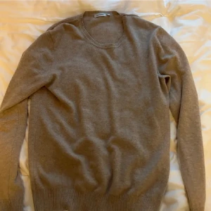 Brun kashmirtröja från J.Lindeberg - Säljer en elegant brun/grå tröja från J.Lindeberg, tillverkad i Italien. Tröjan är gjord i kashmir och merino blanding, vilket ger en lyxig och mjuk känsla. Perfekt för kyligare dagar med sin långärmade design. Inga defekter, skick: 9/10. Tveka inte att höra av dig vid eventuella frågor. Nypris runt 2000.