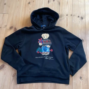 Polo Ralph lauren hoodie - Säljer en svart hoodie från Polo Ralph Lauren. Perfekt för en avslappnad stil. Storlek 14-16 år som passar om man är mellan 160cm-170cm lång. Den har inga defekter och ser ut att vara ny. 