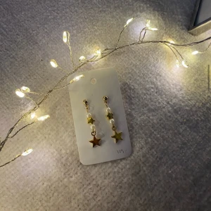 Guldiga hängen med vita pärlor och stjärnor  - Hållbart skapade - Tillverkade i återvunnet material för att bidra till en mer hållbar framtid 