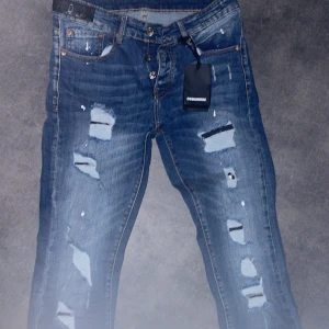 Blå jeans från Dsquared2 - Snygga blå jeans från Dsquared2 med slitna detaljer och en cool, distressed look. De har en klassisk femficksdesign och knappgylf. Perfekta för en avslappnad stil med en touch av edge.