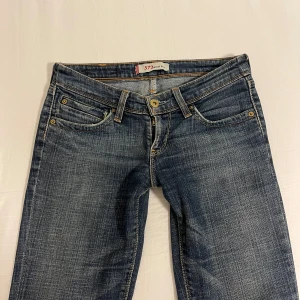 Levi’s jeans - Superfina mörkblå Levi’s jeans i modell 572 bootcut. De är lågmidjade och utsvängda. Vet ej storlek men de är små på mig som brukar ha 36. Skulle kunna vara 34 eller w25? Midjemåttet mätt rakt över är 37,5 cm och innerbenslängden är 73 cm💕kan tyvärr inte ta bild med byxorna på då de är för små för mig☺️