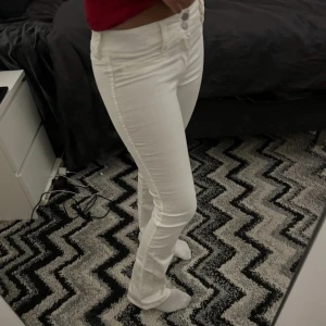 Vita bootcut jeans - Snygga vita bootcut jeans med låg midja och två knappar framtill. Perfekta för en stilren look. Nästan helt nya, bara använt 1 gång. Från h&m