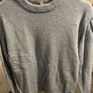 Ljusblå tröja från H&M - Säljer en stilren ljusblå tröja från H&M. Tröjan har en rund halsringning och långa ärmar, perfekt för kyligare dagar. Den är mjuk och bekväm, idealisk för både vardag och avslappnade tillfällen.