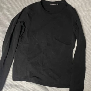 Svart långärmad tröja från ASOS DESIGN - Säljer en stilren svart långärmad tröja från ASOS DESIGN. Perfekt basplagg för garderoben med en normal passform och rund halsringning.