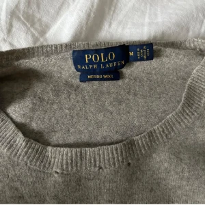 Grå merinoulltröja från Polo Ralph Lauren - Säljer en  grå tröja i mjuk merinoull från Polo Ralph Lauren. Tröjan har en klassisk design med rund hals och ribbstickade muddar. Perfekt för kallare dagar. Fint skick, enda som effekter ser man på bild 1❣️💓