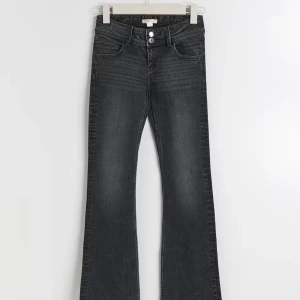 Svarta bootcut jeans - Snygga svarta bootcut jeans med låg midja och dubbla knappar fram. De har stiliga bakfickor . Säljer dom för 100 ,i storlek 152.