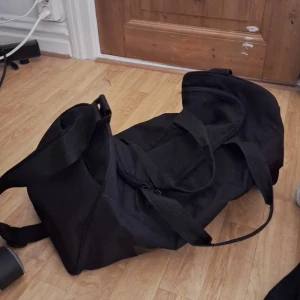 Svart axelväska - Säljer en praktisk svart axelväska med dragkedja. Perfekt för vardagsbruk och enkel att bära med sig.