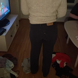 Mörkblå jeans med knappar - Snygga mörkblå jeans med hög midja och knappar framtill. Perfekta för en stilren look.