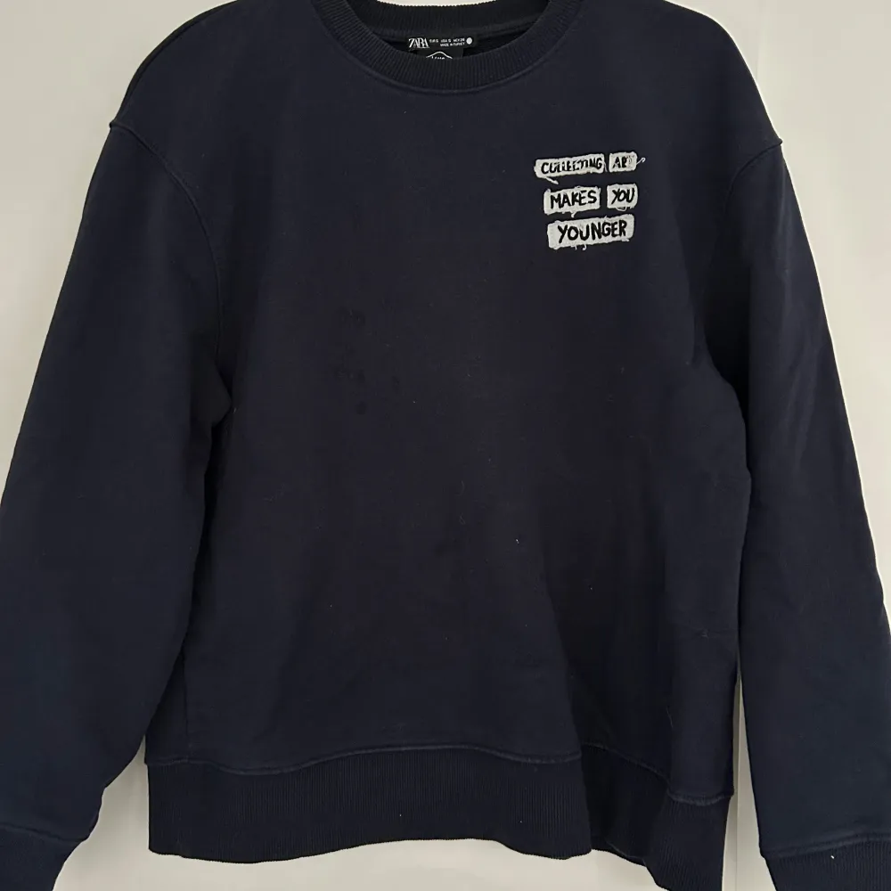 Snygg mörkblå sweatshirt från Zara med texten 'Collecting Art Makes You Younger' tryckt på bröstet och ryggen. Tröjan har långa ärmar och en rund halsringning. Använd fårtal gånger!. Neuletakit & Villapaidat.
