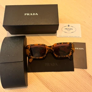 Leopardmönstrade solglasögon från Prada - Superfina, nyköpta solglasögon från Prada med leopardmönster🐆🤎Kommer med originalförpackning och certifikat. Helt oanvända, har inga repor eller tecken på användning. Pris kan diskuteras!