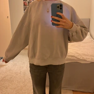 Grå oversized sweatshirt - Säljer en bekväm och stilren grå oversized sweatshirt. Tröjan har långa ärmar och ribbade muddar vid ärmslut och nederkant. Perfekt för en avslappnad look.