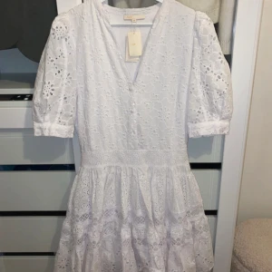 Vit studentklänning från Maje  - Charmig vit klänning i spets med v-ringning och korta ärmar. Den har en vacker öppen rygg och knappar framtill. Perfekt för sommarens festligheter tex student. Klänningen är från Maje 🔥byter gärna annars mot en likadan i en mindre storlek. OBS prislappen är inte kvar längre ( lånade bilder) 
