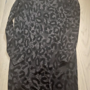 Svart leopardmönstrad klänning - Snygg svart klänning med leopardmönster och långa Klänningen är tillverkad i ett mjukt material. Har typ aldrig använt 🩷