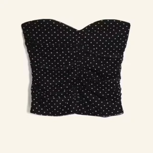 Svart prickig tubtopp - Snygg svart tubtopp med vita prickar, oppen är axelbandslös och har en tight passform. Aldrig använd då jag råkade beställa två stycken🥰hör av dig vid frågor och funderingar🤗