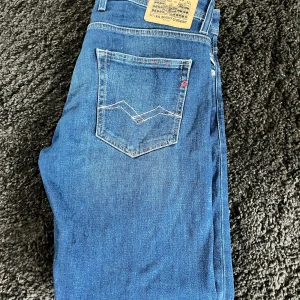 Blå jeans från Replay - Snygga blå jeans från Replay, knappt använda med mycket bra skick. klassisk femficksdesign och broderade detaljer på bakfickorna. De har en normal passform. Tillverkade i slitstarkt denim.