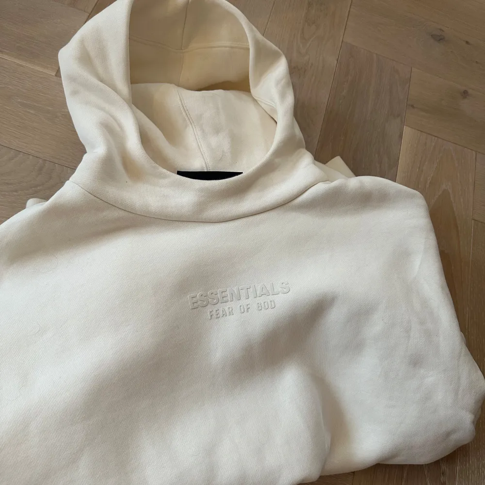 Säljer en stilren beige hoodie från Essentials med broderad logga på bröstet. Tillverkad i en mjuk blandning av bomull och polyester, perfekt för en avslappnad look. Varan är köpt på MR PORTER för cirka 4 månader sedan. Oanvänd.. Neuletakit & Villapaidat.