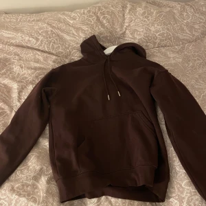 Vinröd hoodie - Säljer en vinröda hoodie med känguruficka och justerbar huva. Perfekt för kyliga dagar och avslappnade stunder. Passar bra till jeans eller mjukisbyxor.