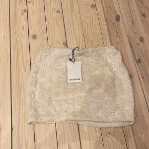 Beige kjol från Bershka - Säljer en snygg beige kjol från Bershka. Helt oanvänd i storlek s.