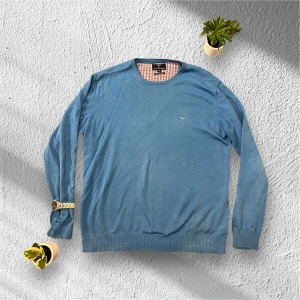 Blå Fynch-Hatton tröja - Säljer en stilren blå tröja från Fynch-Hatton i superfint bomullsmaterial. Tröjan har långa ärmar och en liten logga på bröstet. Perfekt för en avslappnad look. Den har ett litet hål i armhålan annars är den i fint skick! Ställ gärna frågor!