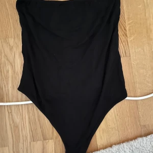 Bandeau body - Svart bandeau body från Nelly. Storlek S 