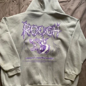 Zip up med print - Grå zip up med lila print på ryggen, i väldigt bra skick och sällan använd. 